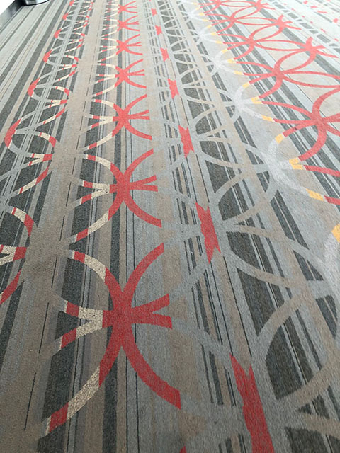 The carpet is light blue and gray striped with interlocking circles in red and yellow.