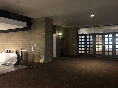 This is a photo of the area off of the Meeting Room level hallway and shows an elevator to the left that goes down to the Bookfair. Also on the left is an escalator leading down to the Bookfair.