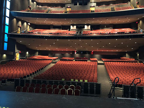 In the Lila Cockrell Theatre, there are three tiers of seating. All the chairs are upholstered in red, and the carpet in the aisles is gray.
