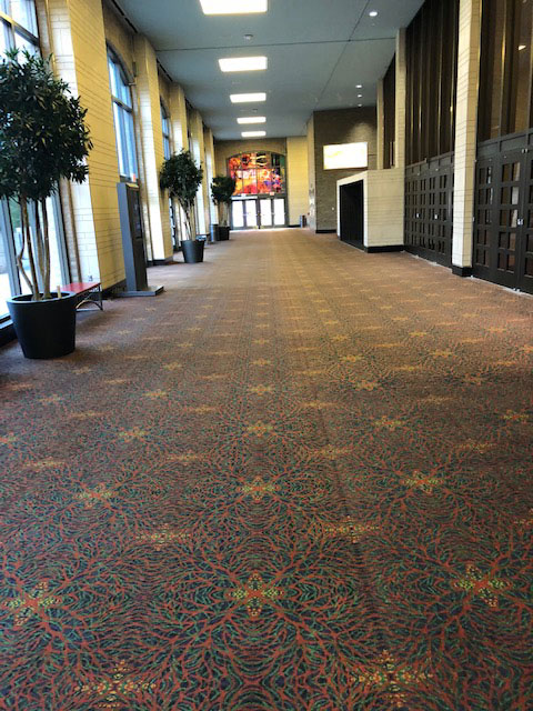 This photo shows a hallway leading from the entrance off Alamo Street to the West Lobby of the Convention Center. On the right of this photo are black doors leading to the Lila Cockrell Theatre.