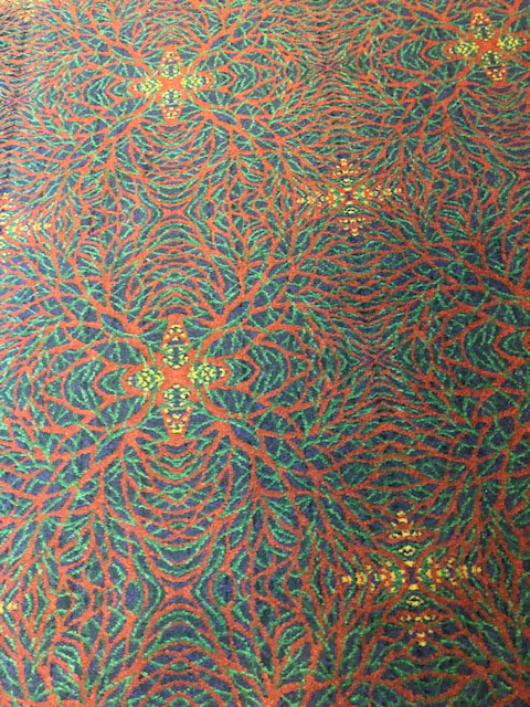 The carpet is a pattern of orange, green, and blue, with yellow stars interspersed.
